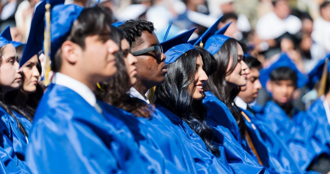 Graduates smile and cheer at the end of the commencement ceremony.